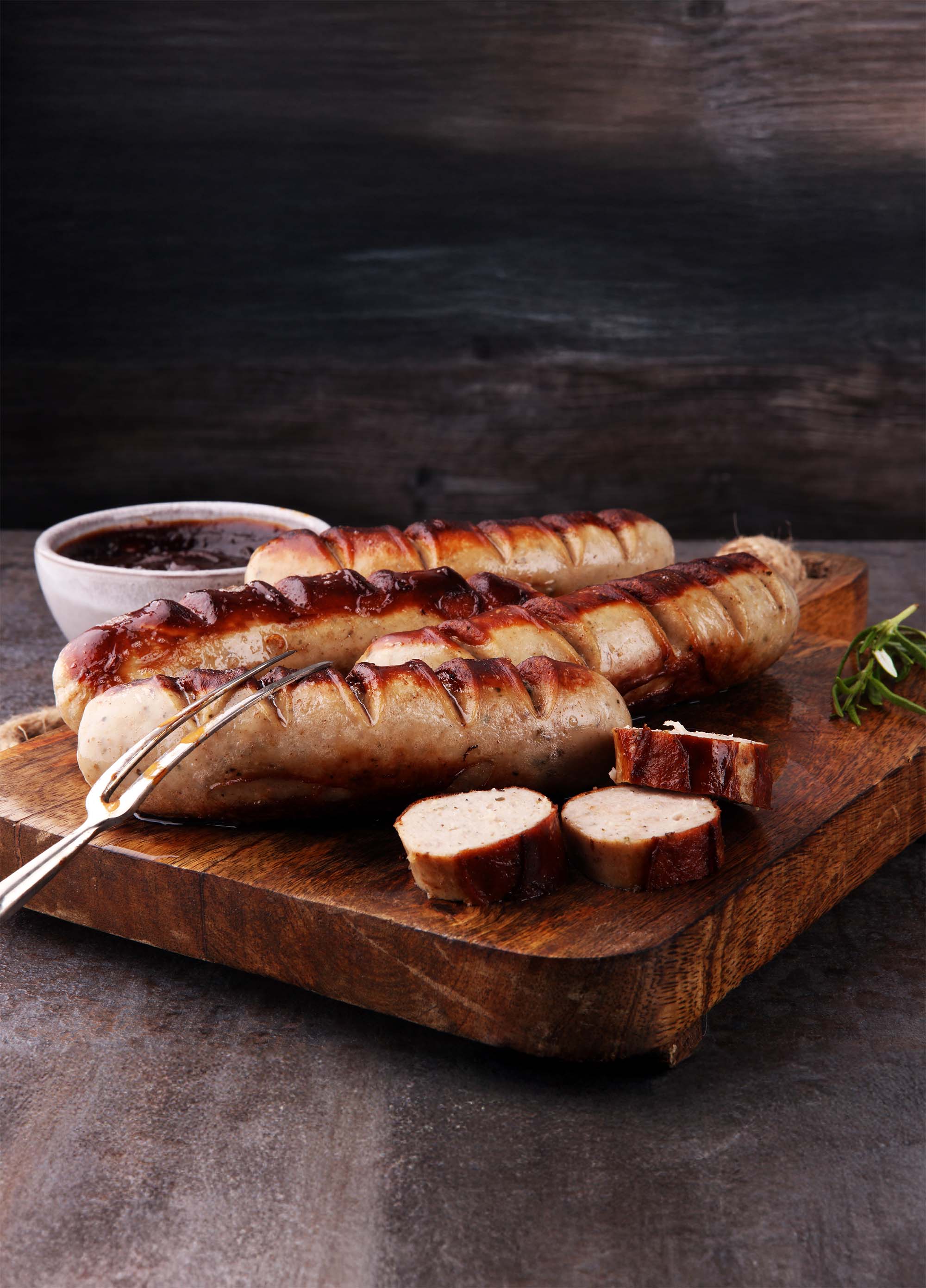 Bratwürste auf Holzbrett mit Soße