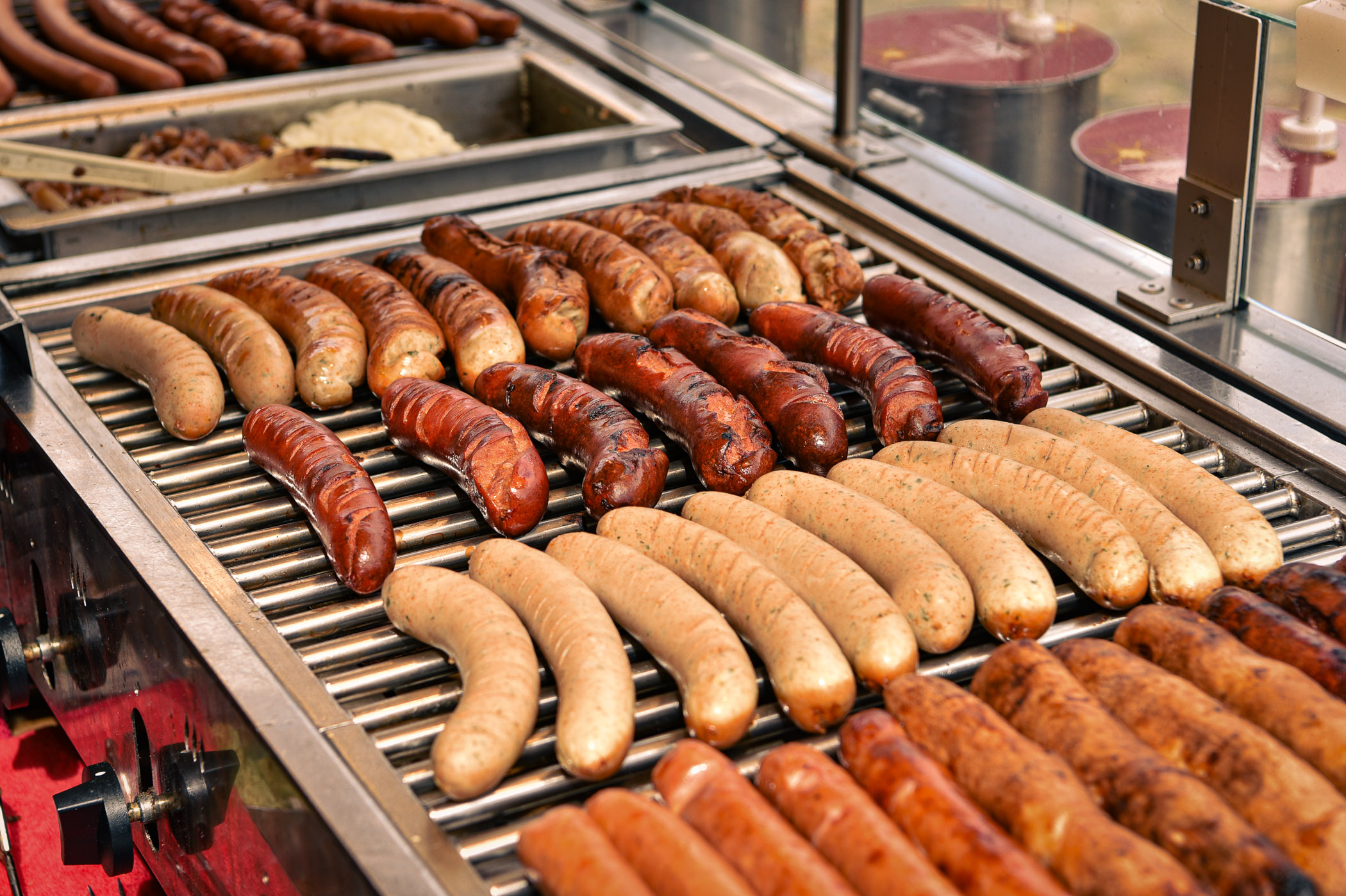Frische Bratwürste und Rostbratwürste auf dem Grill.