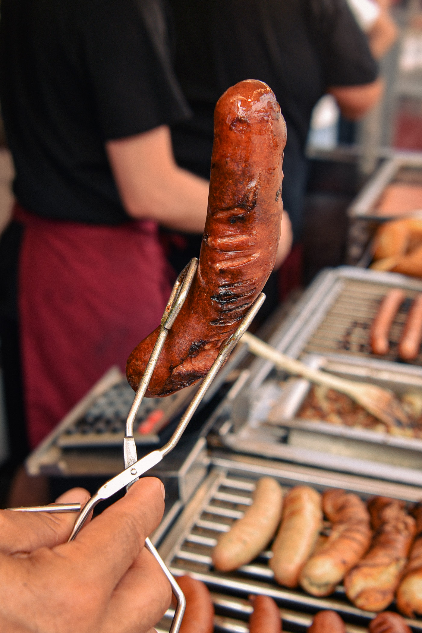 Gegrillte Wurst in Grillzange