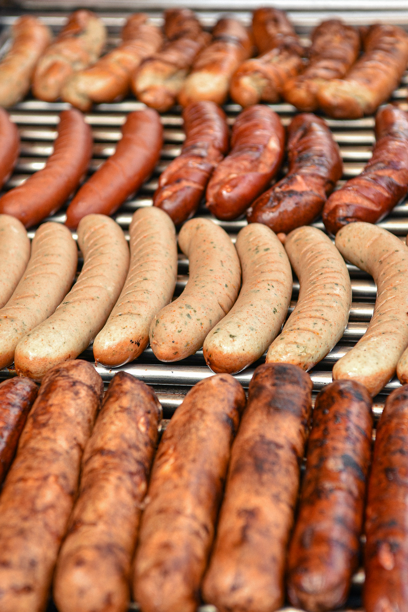 Frische Bratwürste und Rostbratwürste auf dem Grill.